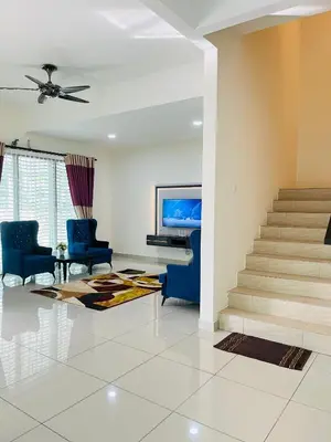 a living room with blue chairs and a piano at Sofea Homestay Ipoh V2 in Ipoh