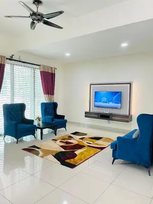 a living room with two blue chairs and a tv at Sofea Homestay Ipoh V2 in Ipoh