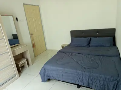 a bedroom with a bed with blue sheets and a mirror at Iman4 Homestay in Kampung Behrang