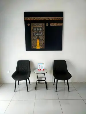 two chairs and a table with a picture on the wall at Iman4 Homestay in Kampung Behrang