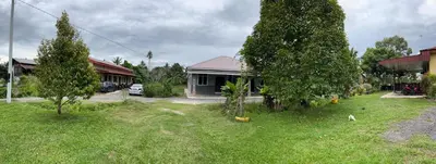 a yard with two trees and a house at Nabilah Homestay Labuh Banting in Kepala Batas