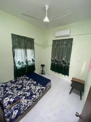 a bedroom with a bed and two windows with curtains at Nabilah Homestay Labuh Banting in Kepala Batas