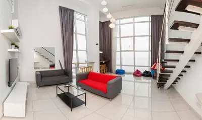 a living room with a red couch and a staircase at Maritime Luxury Suite Seaview Sunrise in George Town