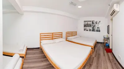 two beds in a room with white walls and wooden floors at Maritime Luxury Suite Seaview Sunrise in George Town
