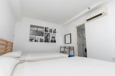 a white bedroom with two beds and a picture on the wall at Maritime Luxury Suite Seaview Sunrise in George Town