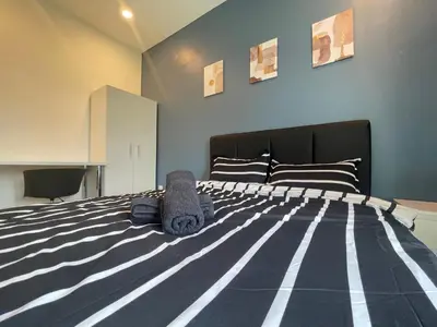a bedroom with a bed with a black and white comforter at The Anderson Residence Ipoh#1018 in Ipoh
