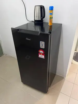 a black refrigerator with a coffee pot on top of it at AYAAN COZY PRIMA HOMESTAY FREE WiFi in Tanah Rata