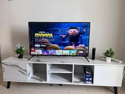 a flat screen tv sitting on top of a white entertainment center at AYAAN COZY PRIMA HOMESTAY FREE WiFi in Tanah Rata