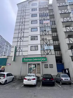 a large building with cars parked in a parking lot at AYAAN COZY PRIMA HOMESTAY FREE WiFi in Tanah Rata