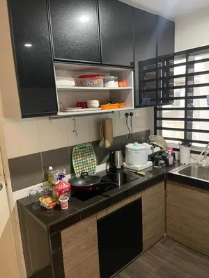 a kitchen with black cabinets and a counter top at AYAAN COMFY PRIMA HOMESTAY FREE WiFi in Tanah Rata