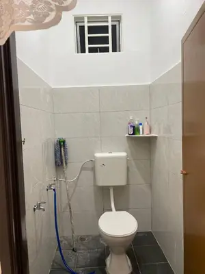 a small bathroom with a toilet and a window at Nona Homestay in Parit Buntar