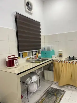 a kitchen with a sink and a counter top at Nona Homestay in Parit Buntar