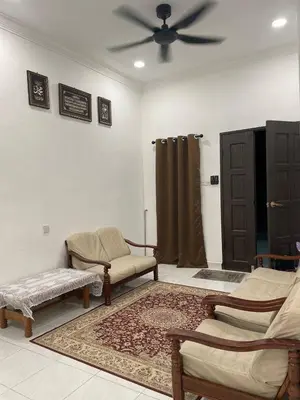 a living room with chairs and a ceiling fan at Nona Homestay in Parit Buntar