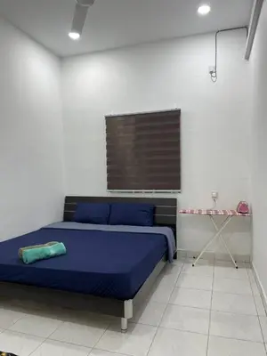 a bedroom with a blue bed and a window at Nona Homestay in Parit Buntar