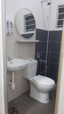 a bathroom with a toilet and a sink and a mirror at The SAFYYA House Teluk Senangin in Lumut