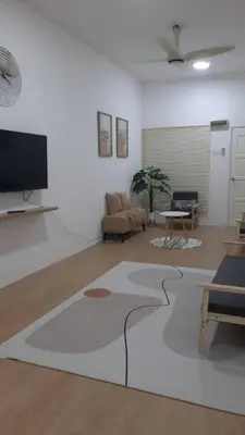 a living room with a couch and a tv at The SAFYYA House Teluk Senangin in Lumut