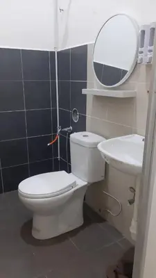 a bathroom with a toilet and a sink and a mirror at The SAFYYA House Teluk Senangin in Lumut