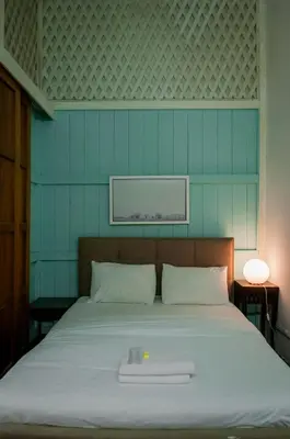 a bed in a room with a blue wall at Aayu Heritage - Heritage Home in Stewart Lane in George Town