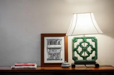 a green lamp sitting on a table next to a picture at Aayu Heritage - Heritage Home in Stewart Lane in George Town