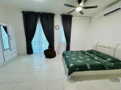 a bedroom with a green bed and black curtains at Zalins CozyHome 3BR - Double Storey Terrace in Kepala Batas