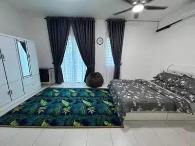 a bedroom with a bed and a tropical print rug at Zalins CozyHome 3BR - Double Storey Terrace in Kepala Batas