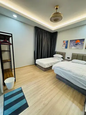 a bedroom with two beds and a wooden floor at AYAAN PLATINUM Foosball Home at Quintet Apartment Free Parking in Tanah Rata