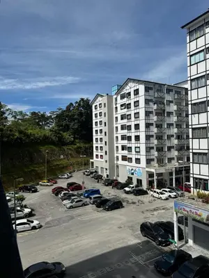 a parking lot with cars parked in front of buildings at AYAAN LAVISH PRIMA APARTMENT FREE WiFi in Tanah Rata