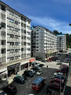 a parking lot with cars parked in front of tall buildings at AYAAN LAVISH PRIMA APARTMENT FREE WiFi in Tanah Rata