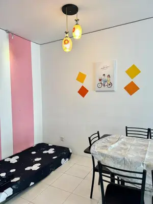 a room with a bed and a table with chairs at AYAAN LAVISH PRIMA APARTMENT FREE WiFi in Tanah Rata