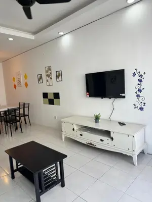 a living room with a tv on a white wall at AYAAN LAVISH PRIMA APARTMENT FREE WiFi in Tanah Rata
