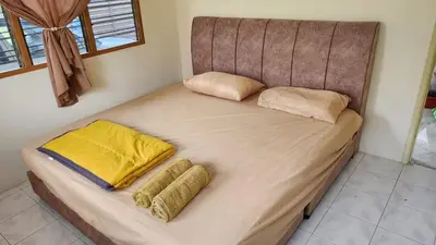 a large bed with two pillows on top of it at Vacation Ipoh Homestay for 12 Pax 4 Bedrooms for Delicious Food in Ipoh