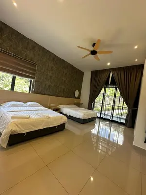 a bedroom with two beds and a ceiling fan at Adik Aisyah cameron semi-D goleden hill homestay in Brinchang
