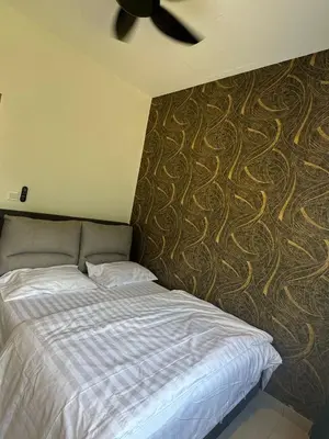 a bedroom with a bed and a ceiling fan at Adik Aisyah cameron semi-D goleden hill homestay in Brinchang