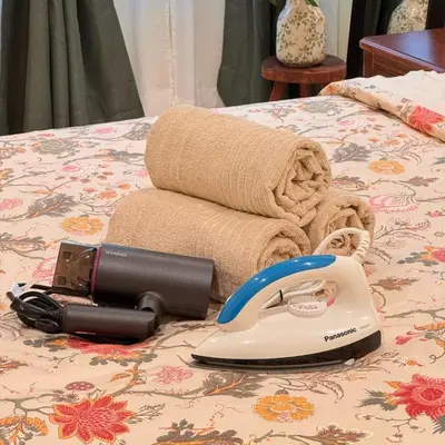 a hair dryer and towels on a bed with a phone at The Heritage 3BR Apartment at Town Centre in Ipoh