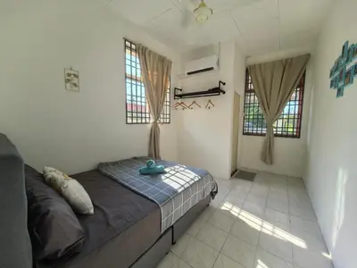 a bedroom with a bed in a room with windows at Padang Serai Harmoni Homestay in Padang Serai