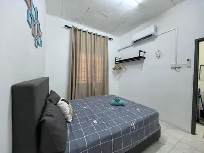 a room with a bed and a couch in it at Padang Serai Harmoni Homestay in Padang Serai