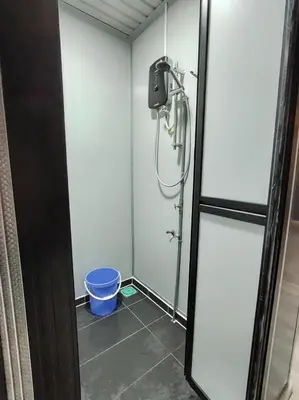 a bathroom with a shower with a bucket in it at ZR Homestay in TanjongMalim