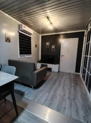 a living room with a couch and a television at ZR Homestay in TanjongMalim