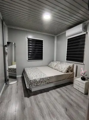 a bedroom with a bed and two windows at ZR Homestay in TanjongMalim