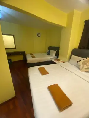 a hotel room with two beds with brown napkins on them at Highlanders Apartment in Tanah Rata