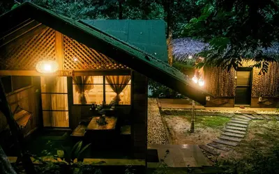 a house with a staircase leading up to it at night at Escape to Nature Cozy Terrace Room by the River in Kampong Ulu Dong