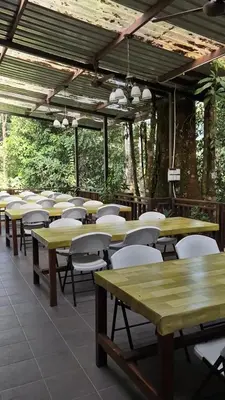 a row of tables and chairs in a restaurant at Escape to Nature Cozy Terrace Room by the River in Kampong Ulu Dong