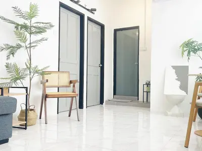 a room with doors and chairs and a plant at Muji Zen Minimalist Guest House in Teluk Intan