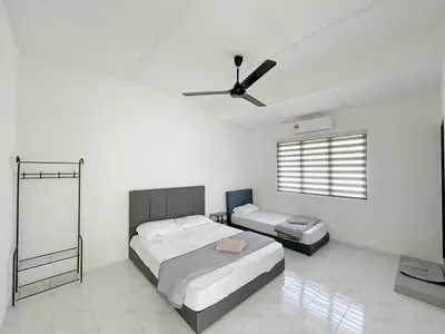 a bedroom with two beds and a ceiling fan at Muji Zen Minimalist Guest House in Teluk Intan