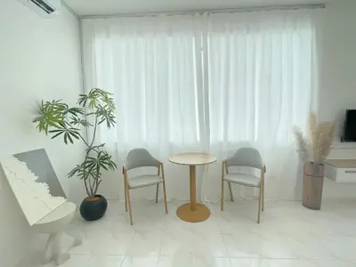 a room with a table and chairs and a window at Muji Zen Minimalist Guest House in Teluk Intan