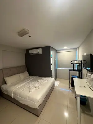 a bedroom with a bed and a desk and a television at Georgetown Hotel in George Town