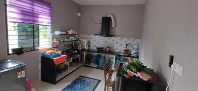 a kitchen with a counter and a table with chairs at Inap hujung kampung in Penaga