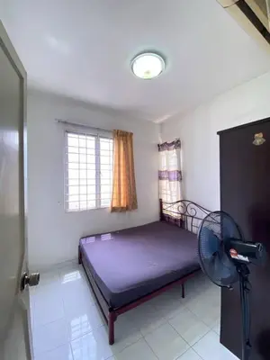 a bedroom with a purple bed and a fan at sunny point complex in Gelugor