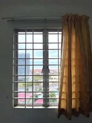 a window with a curtain in a room at sunny point complex in Gelugor