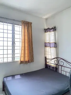 a bed in a room with two windows at sunny point complex in Gelugor